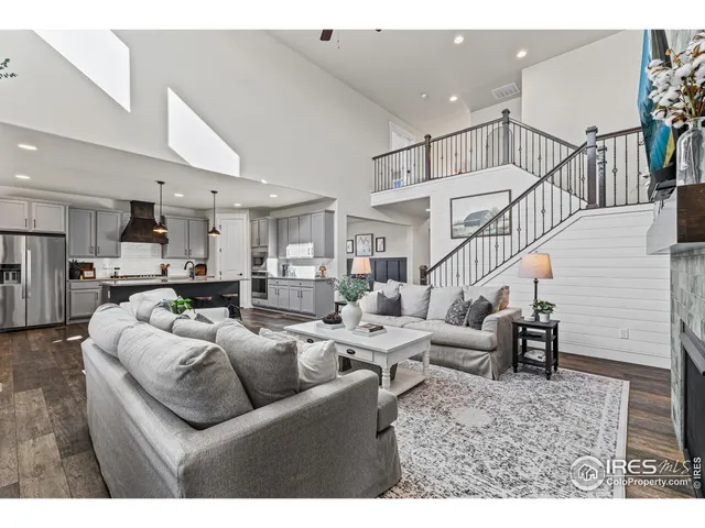 a living room with furniture kitchen view and a chandelier
