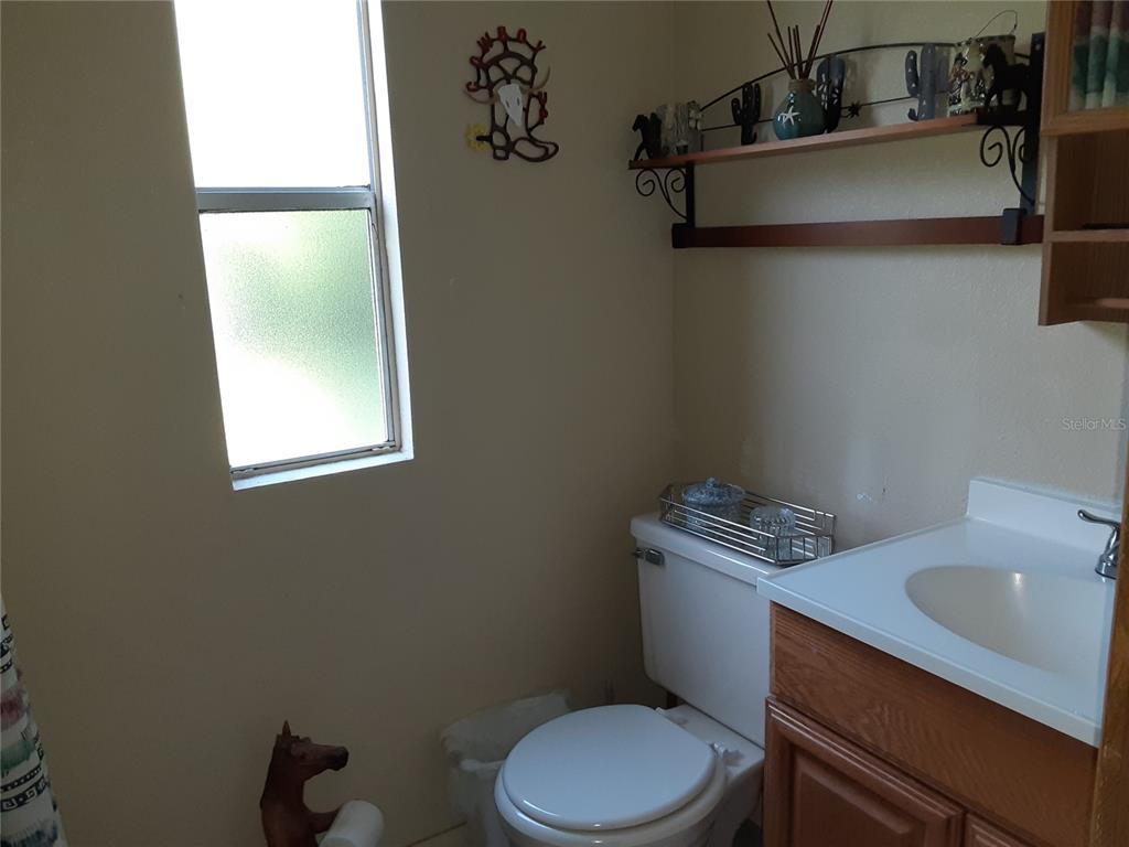 8333 Kathleen Road Lakeland, FL 33810 - Photo 13 of 24 a white toilet sitting next to a bathroom sink