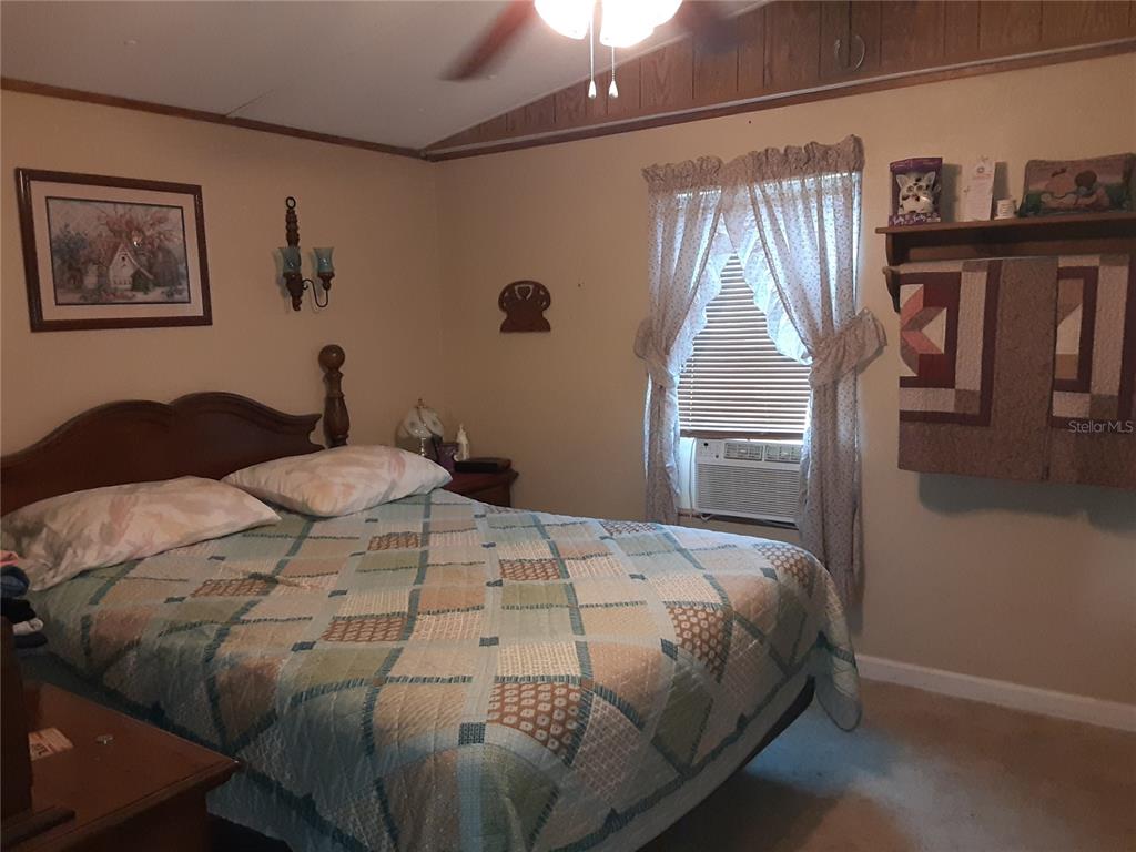 8333 Kathleen Road Lakeland, FL 33810 - Photo 9 of 24 a bedroom with a bed and a chandelier