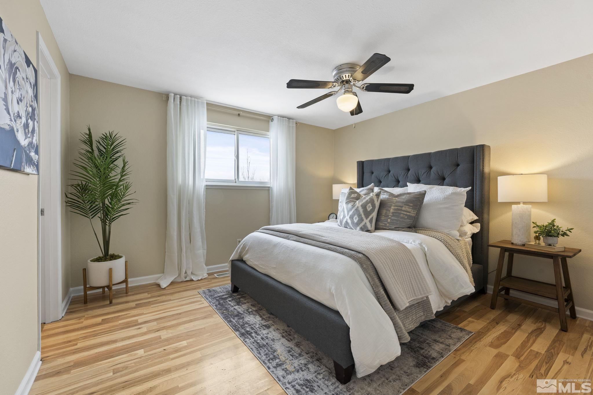 14070 Tourmaline Drive Reno, NV 89521 - Photo 16 of 39 a bedroom with a bed lamp and a potted plant