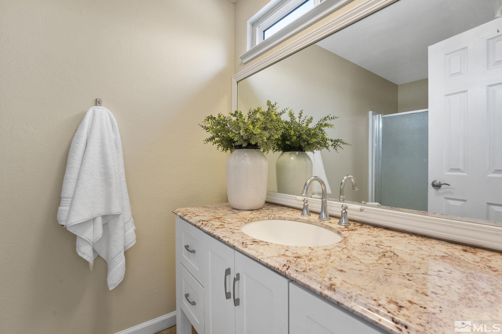 14070 Tourmaline Drive Reno, NV 89521 - Photo 19 of 39 a bathroom with a granite countertop sink and a mirror
