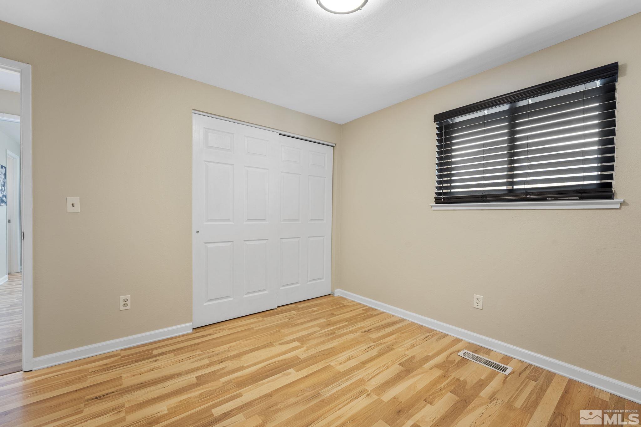 14070 Tourmaline Drive Reno, NV 89521 - Photo 21 of 39 a view of empty room with wooden floor and fan