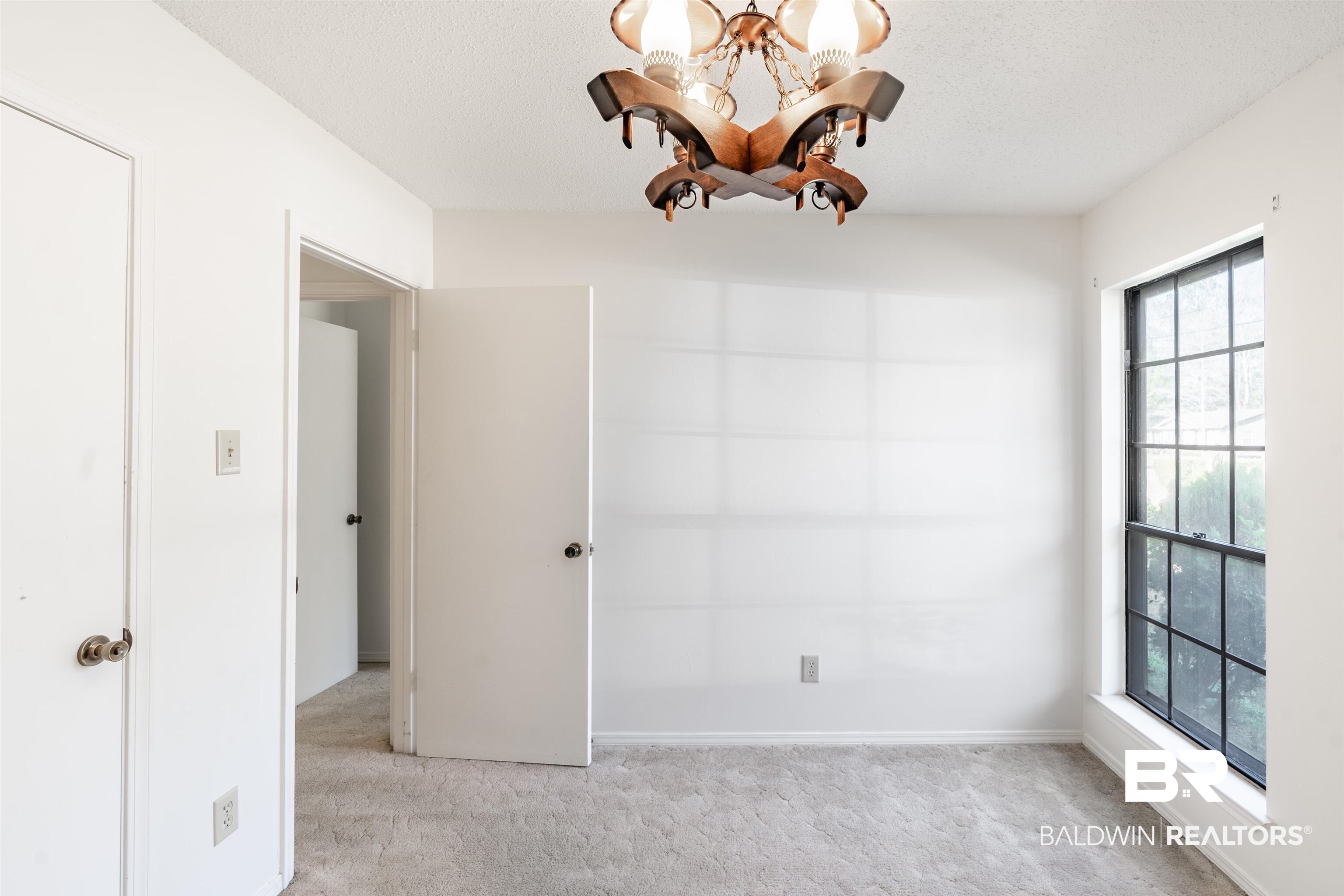 9751 Pine Knoll Road Mobile, AL 36608 - Photo 22 of 36 Empty room featuring hanging lights, light carpet, and a textured ceiling