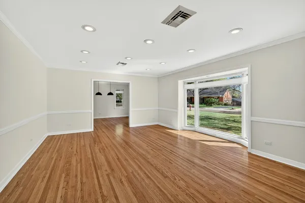 a view of empty room with wooden floor