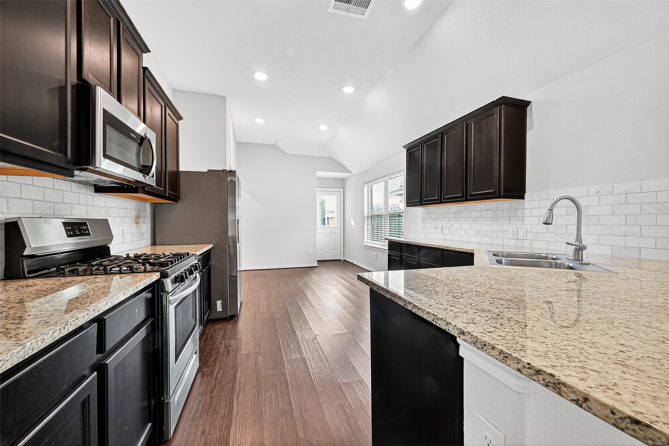 5603 Savanna Pasture Road Katy, TX 77493 - Photo 7 of 29 a kitchen with stainless steel appliances granite countertop a sink stove microwave and refrigerator