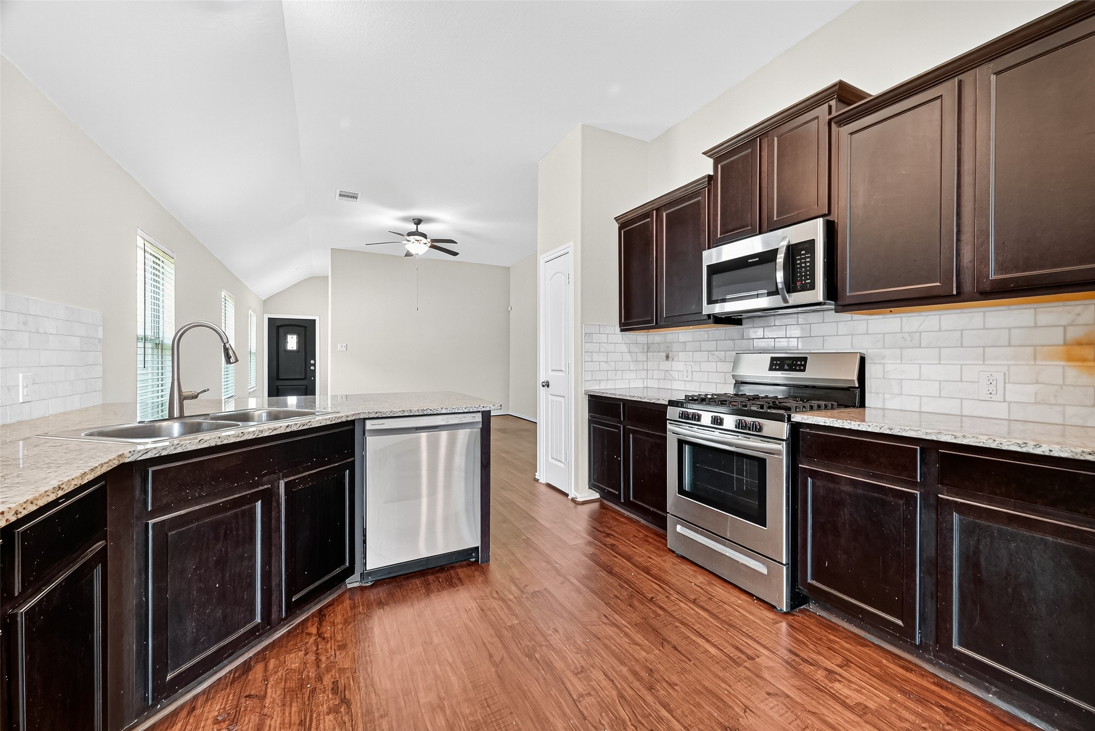 5603 Savanna Pasture Road Katy, TX 77493 - Photo 8 of 29 a kitchen with stainless steel appliances kitchen island granite countertop a stove top oven and sink