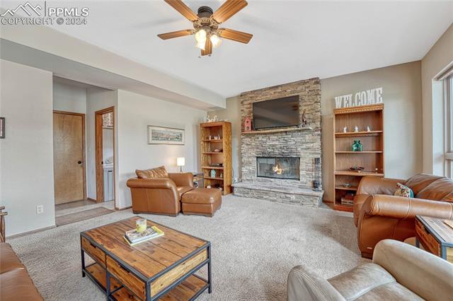 2690 Spaatz Road Monument, CO 80132 - Photo 12 of 50 Carpeted living room with ceiling fan and a fireplace