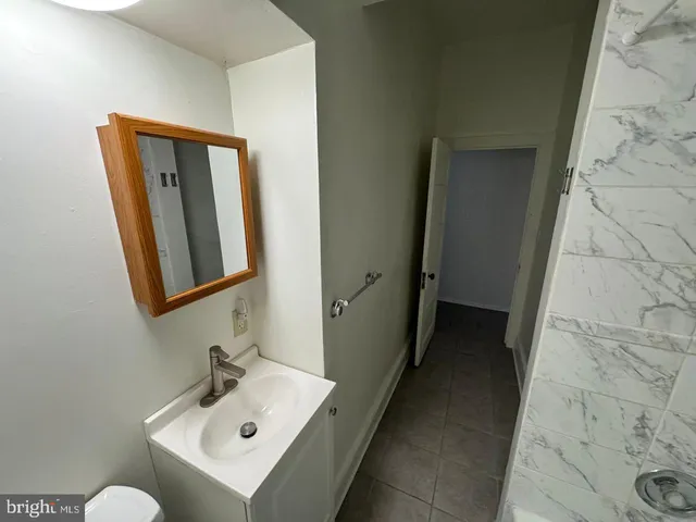 a bathroom with a sink mirror and toilet