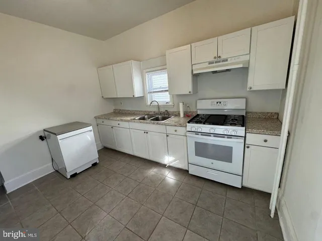 a kitchen with a stove sink and cabinets