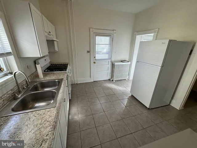 a kitchen with a sink a refrigerator and cabinets
