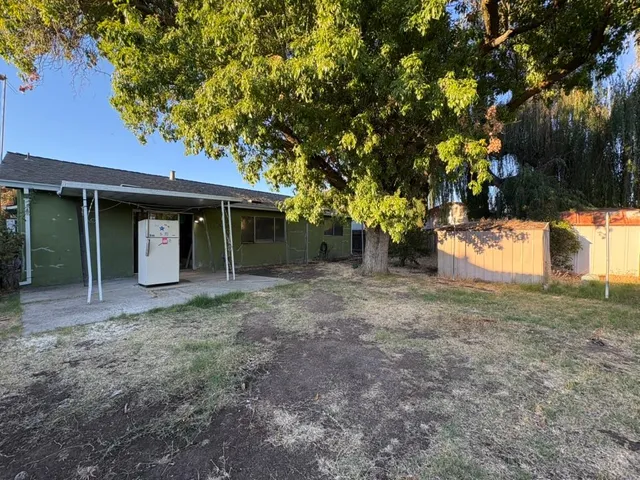 a view of a house with a yard and tree