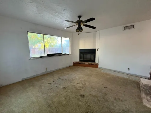 a view of a livingroom with a ceiling fan and window