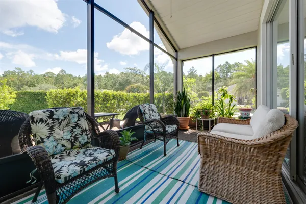 a living room with furniture and floor to ceiling windows