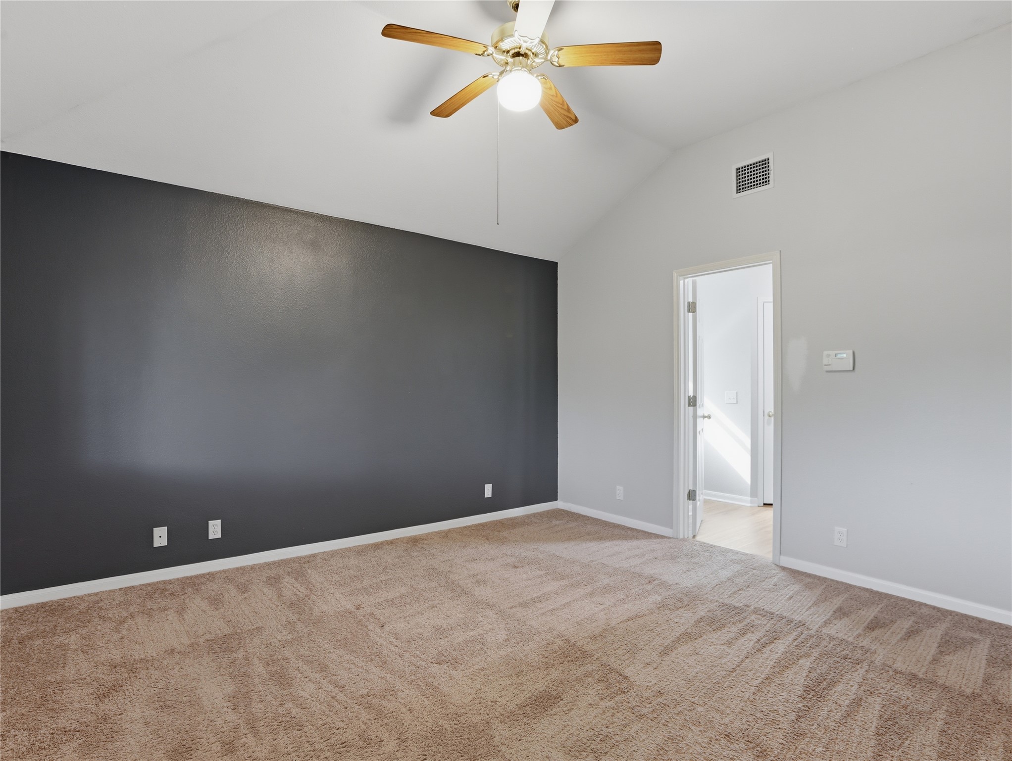 168 Keystone Loop Kyle, TX 78640 - Photo 11 of 23 Spare room featuring vaulted ceiling, a ceiling fan, and light colored carpet