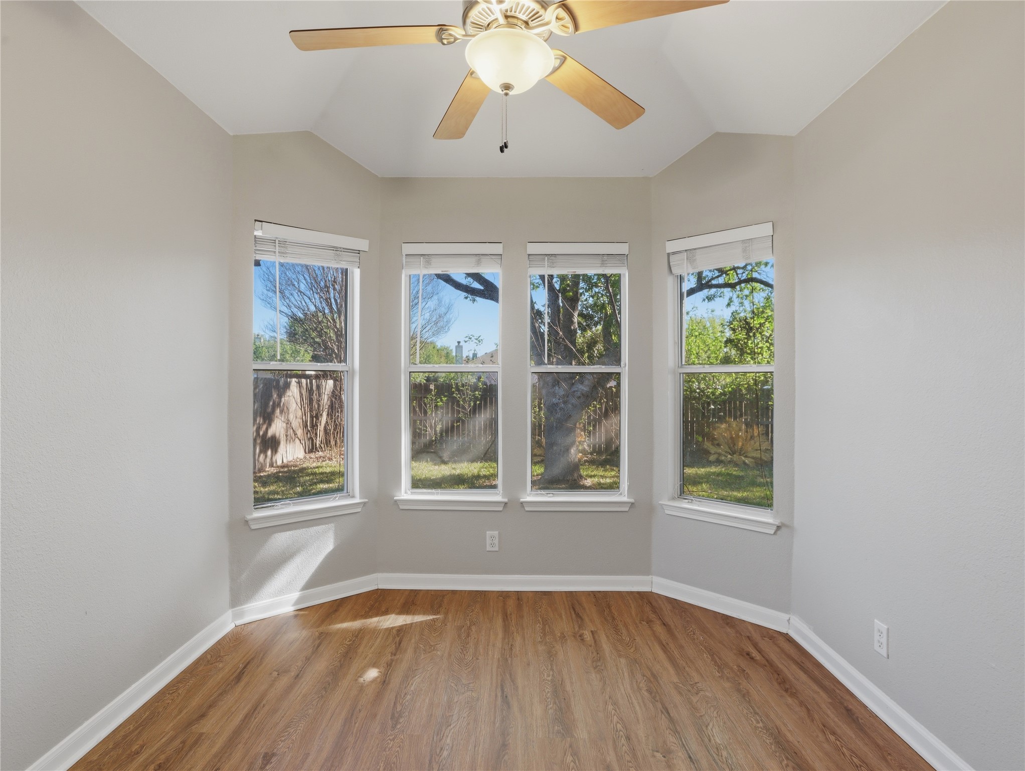168 Keystone Loop Kyle, TX 78640 - Photo 15 of 23 Empty room featuring light wood-style flooring, vaulted ceiling, a ceiling fan, and plenty of natural light