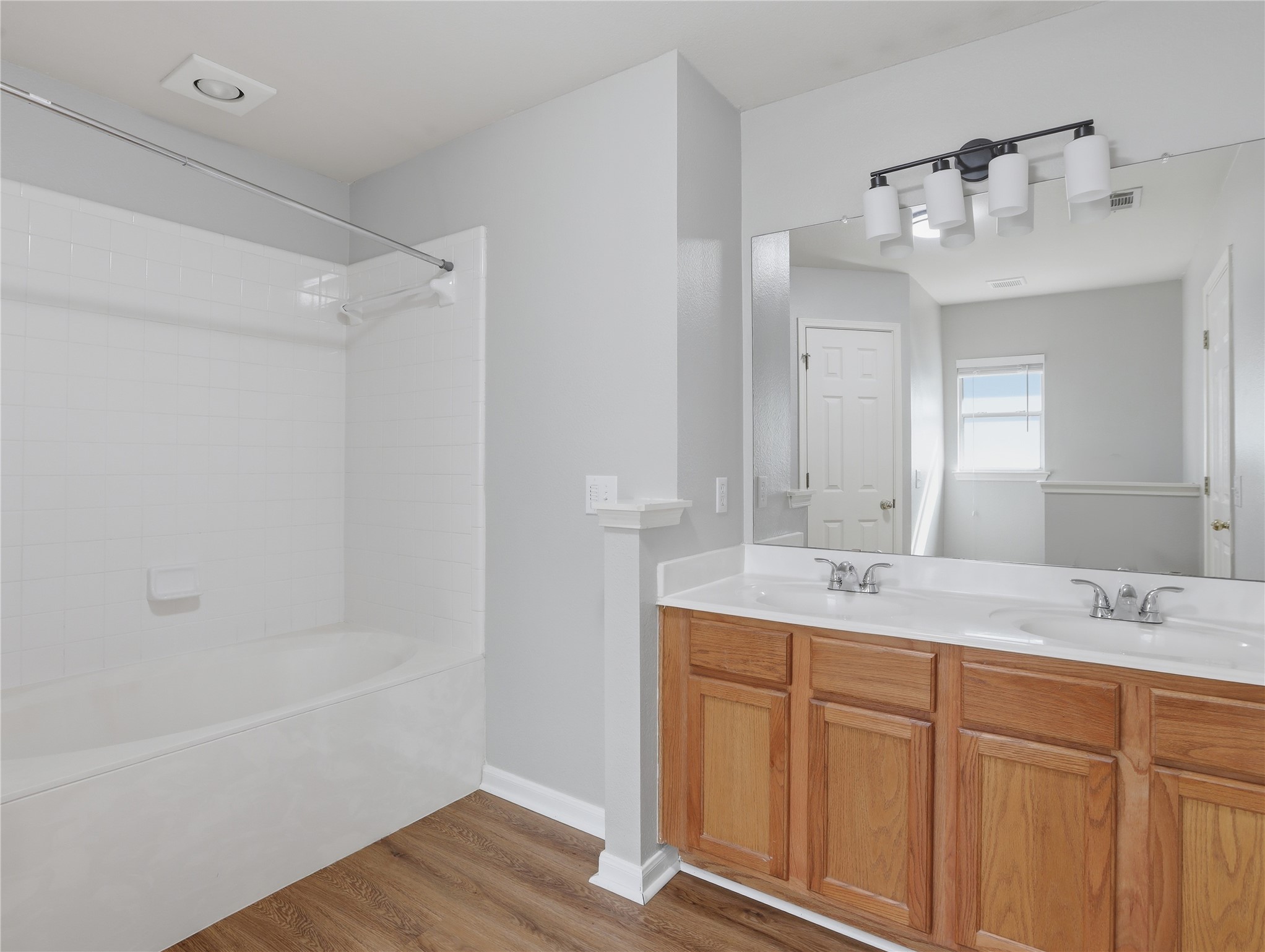 168 Keystone Loop Kyle, TX 78640 - Photo 17 of 23 Bathroom with double vanity, bathtub / shower combination, and light wood-style floors