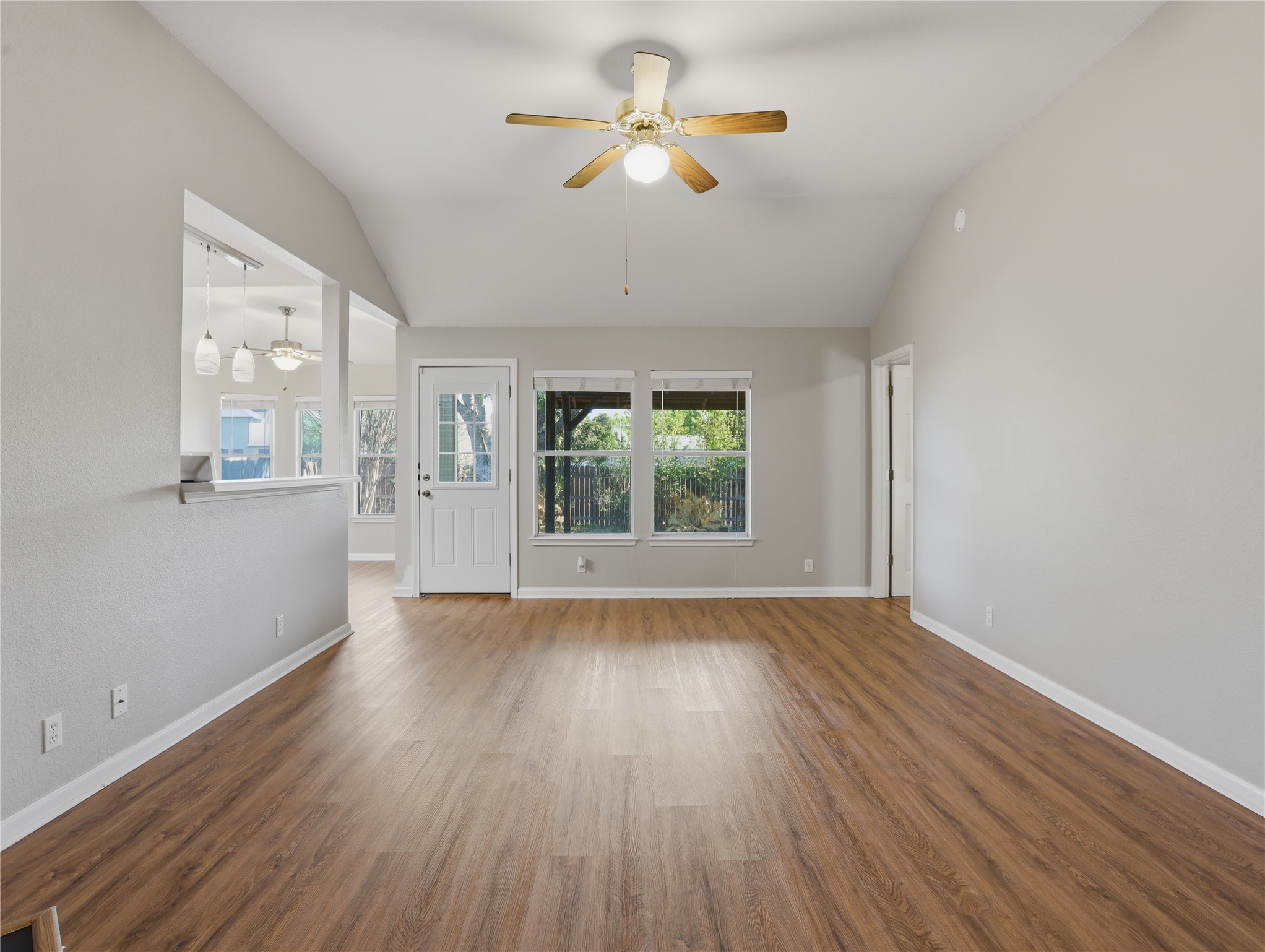 168 Keystone Loop Kyle, TX 78640 - Photo 4 of 23 Unfurnished living room featuring ceiling fan, vaulted ceiling, and dark wood-style floors