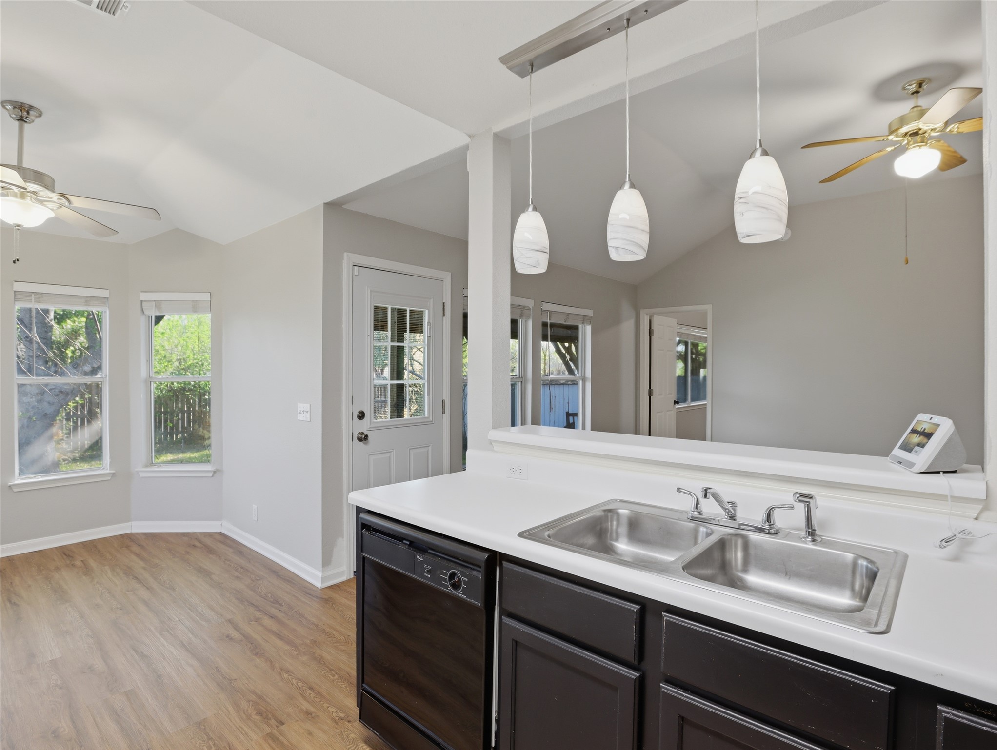 168 Keystone Loop Kyle, TX 78640 - Photo 9 of 23 Kitchen with ceiling fan, light countertops, dishwasher, lofted ceiling, and hanging light fixtures