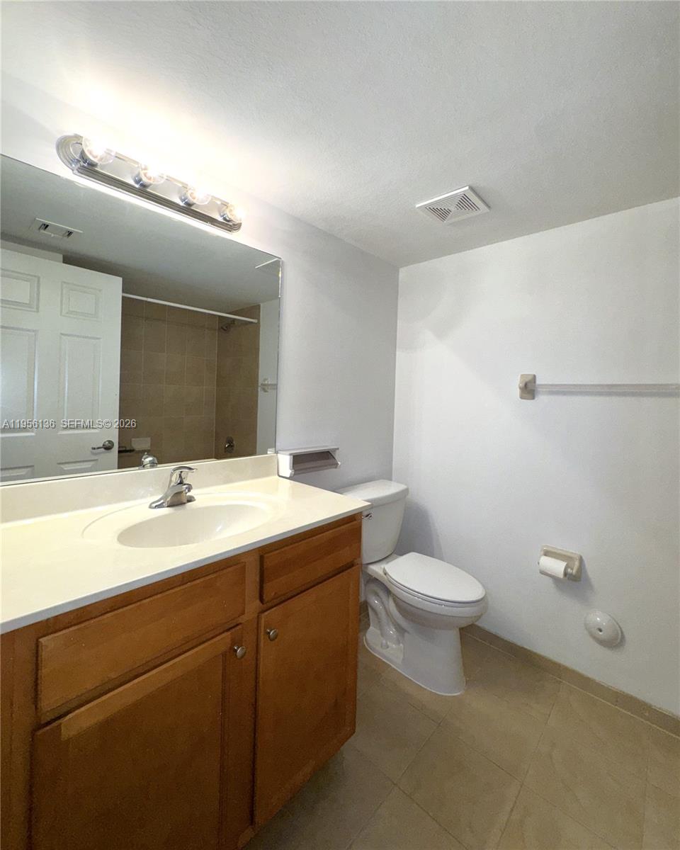 22441 Southwest 88th Place, Unit 2015 Cutler Bay, FL 33190 - Photo 12 of 19 a bathroom with a toilet a sink and mirror