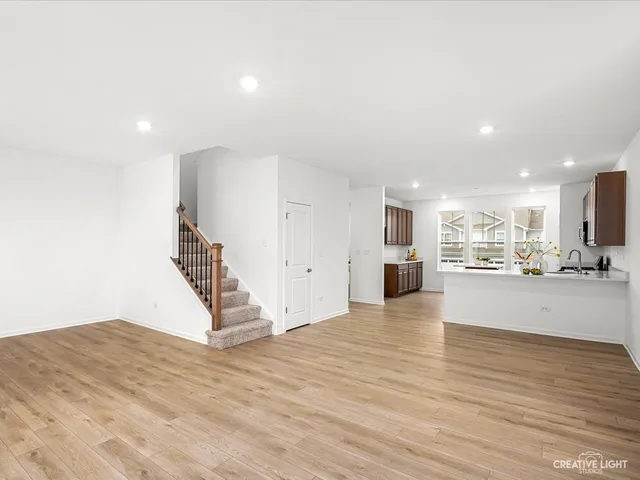 a view of a living room a wooden floor and kitchen view