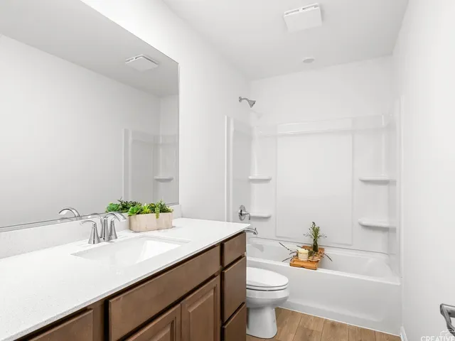 a bathroom with a sink a toilet and a large mirror