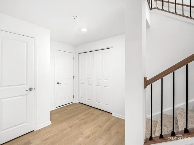 a view of a hallway with wooden floor and entryway