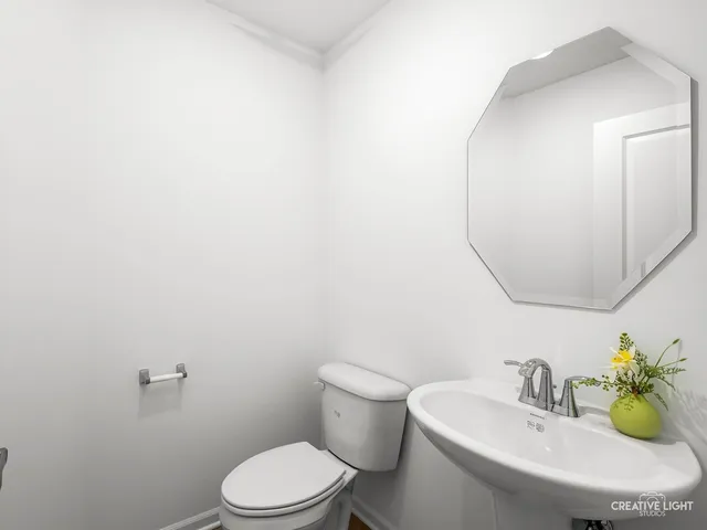 a bathroom with a sink mirror and toilet