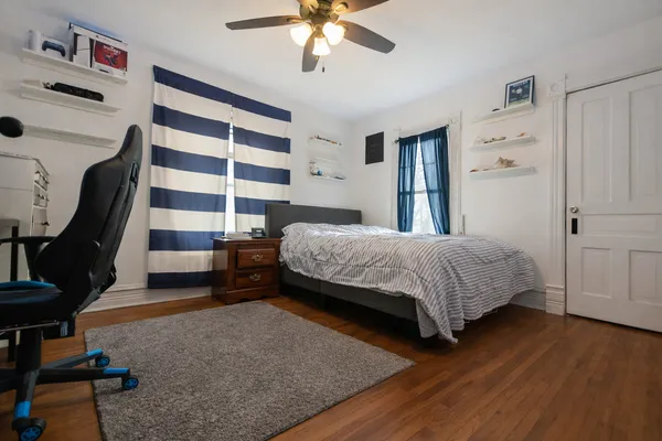 a bedroom with a bed a dresser and book shelf