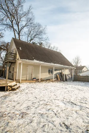 a front view of a house with a yard covered in snow