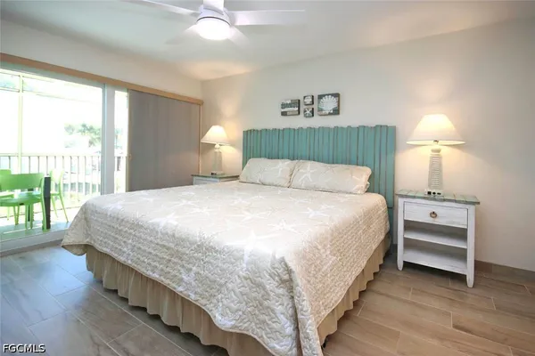 a bedroom with a bed and a large window with wooden floor