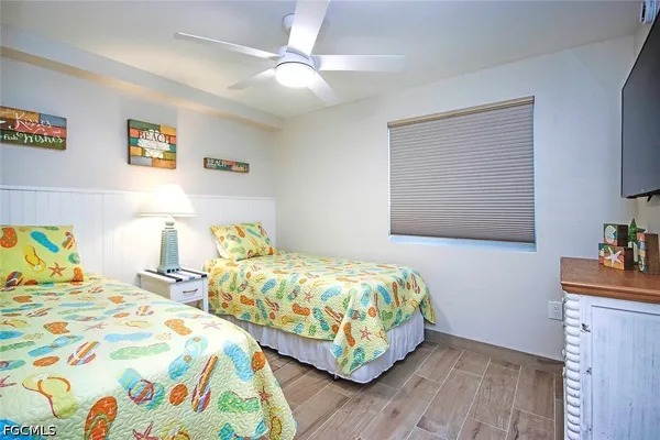 a bedroom with two beds and painting on the wall