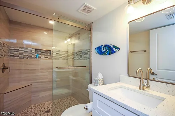 a bathroom with a sink a toilet and shower