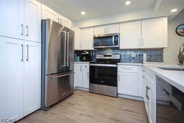 a kitchen with white cabinets and stainless steel appliances