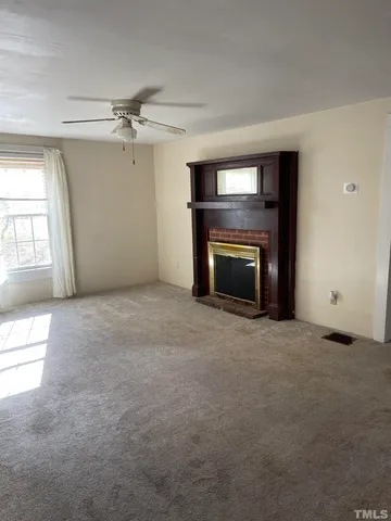 an empty room with fireplace and windows