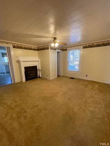 en empty room with windows and fireplace