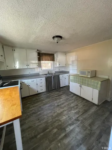 a large kitchen with lots of counter space and wooden floor