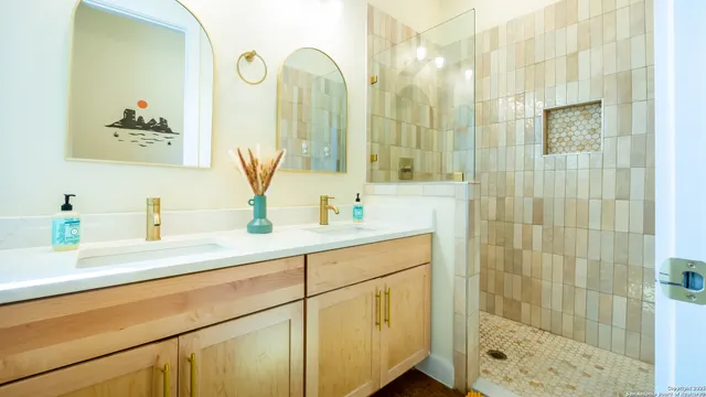 a bathroom with a double vanity sink mirror and shower