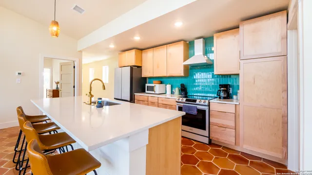 a kitchen with kitchen island a counter top space appliances and cabinets