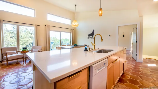a kitchen with kitchen island a sink a stove and a dining table with wooden cabinet