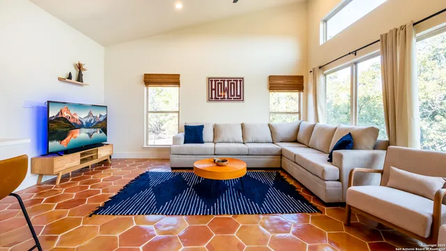 a living room with furniture a rug and a flat screen tv