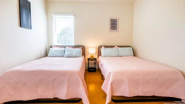 a bedroom with two beds and a window