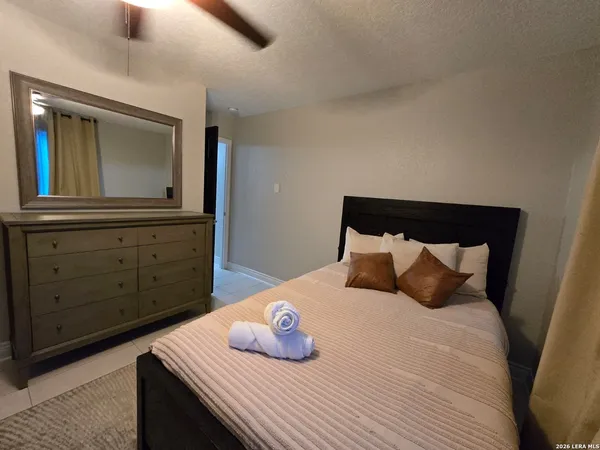 a bedroom with a bed and dresser with mirror