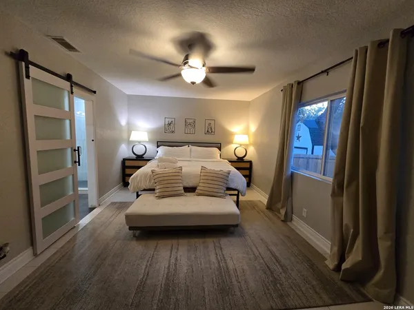 a bedroom with a large bed and a chandelier
