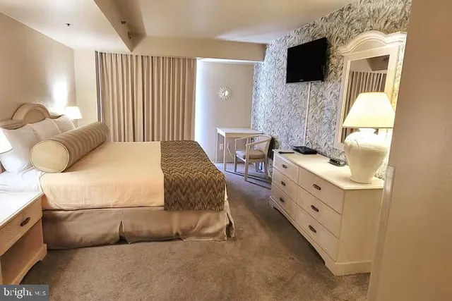 a bedroom with a bed and flat screen tv