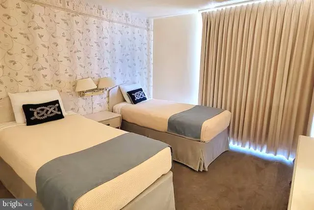 a bedroom with two beds and a desk