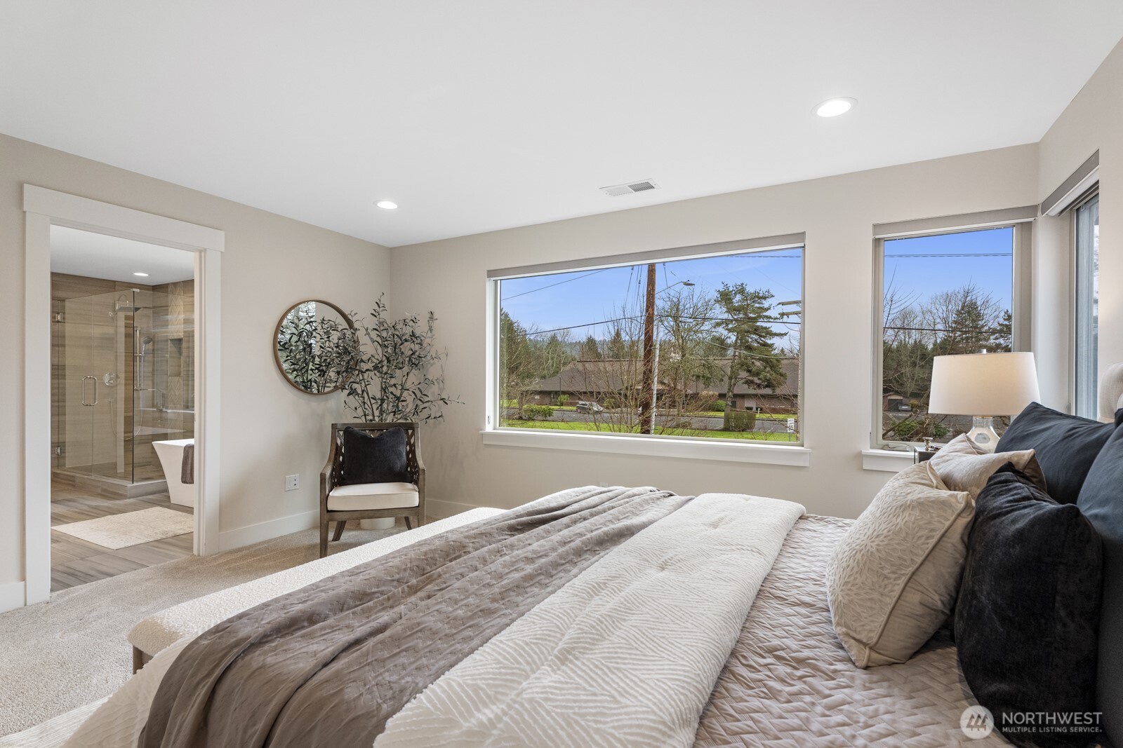 4526 327th Place Northeast Carnation, WA 98014 - Photo 18 of 36 a bedroom with a bed and large windows