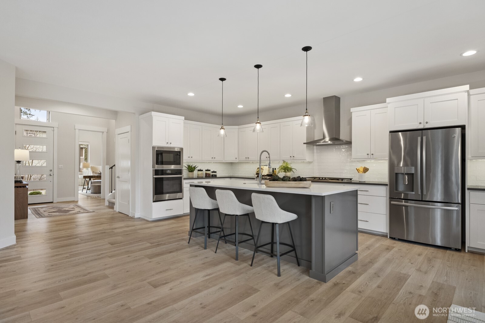 4526 327th Place Northeast Carnation, WA 98014 - Photo 4 of 36 a kitchen with stainless steel appliances granite countertop a refrigerator a stove a sink dishwasher and a dining table with wooden floor