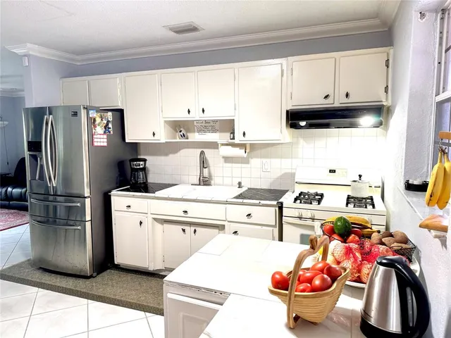 a kitchen with stainless steel appliances kitchen island granite countertop a refrigerator and microwave