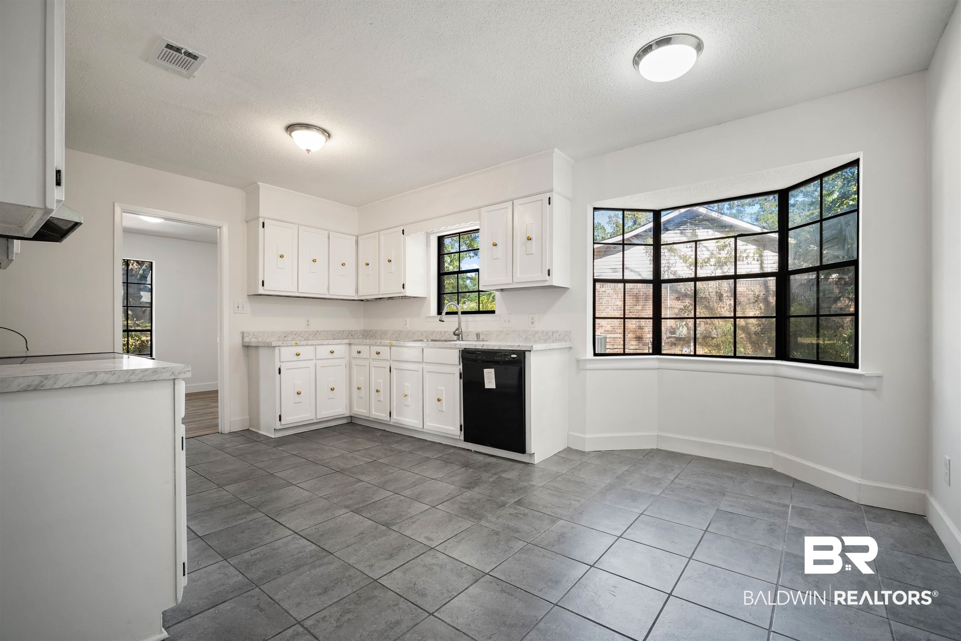 6521 Valor Court Mobile, AL 36618 - Photo 10 of 29 Kitchen with white cabinets, dishwasher, sink, tile patterned flooring, and a textured ceiling