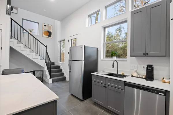 a kitchen with sink a refrigerator and cabinets